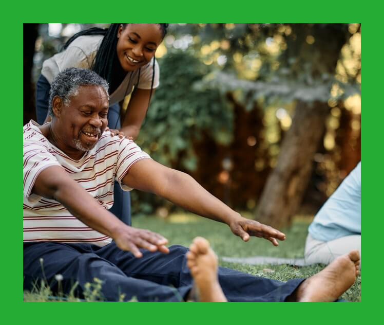 Older man stretching, supported by younger female