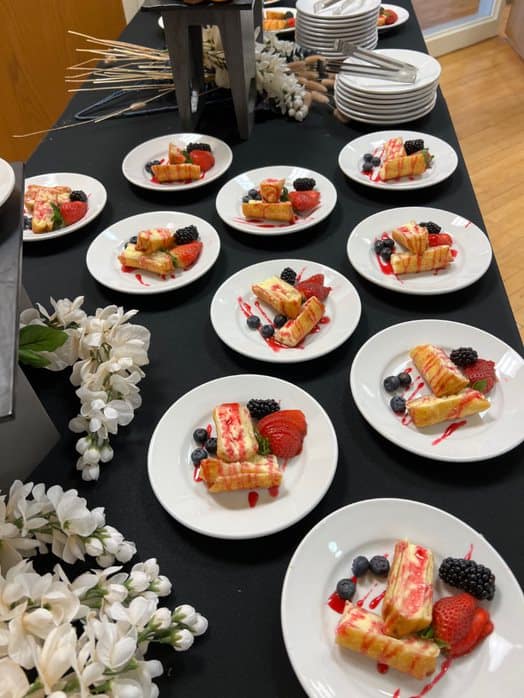 Table covered in plated desserts, buffet